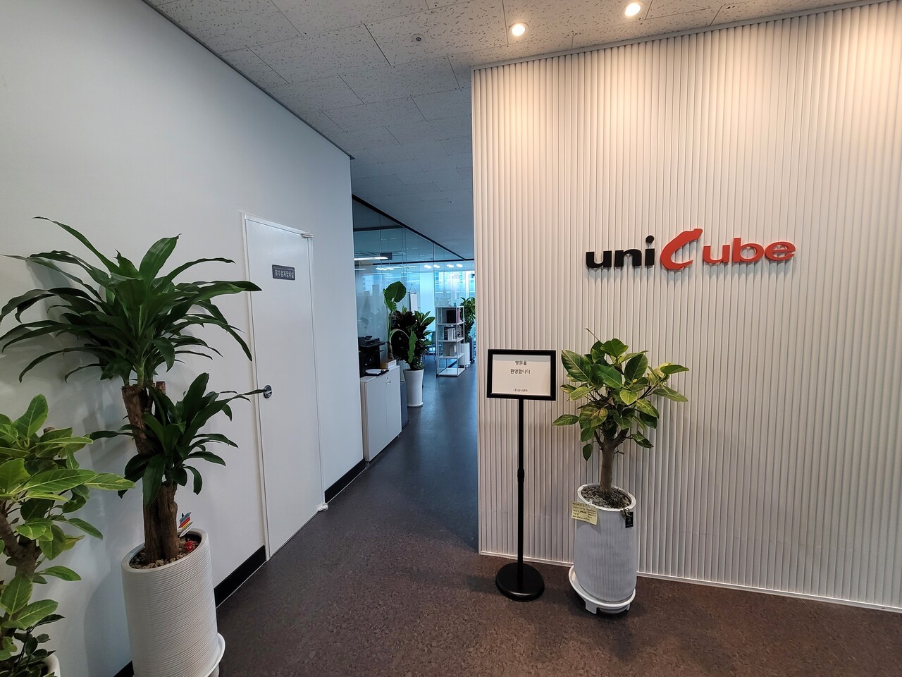 유니큐브 본사 입구. 고객 중심 비즈니스 솔루션 기업으로의 정체성을 상징하는 브랜드 로고가 눈에 띈다.