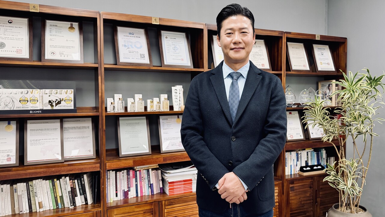 우성민 ㈜네트론 대표가 회사의 대표 제품과 각종 인증·수상 내역이 전시된 공간에서 포즈를 취하고 있다.